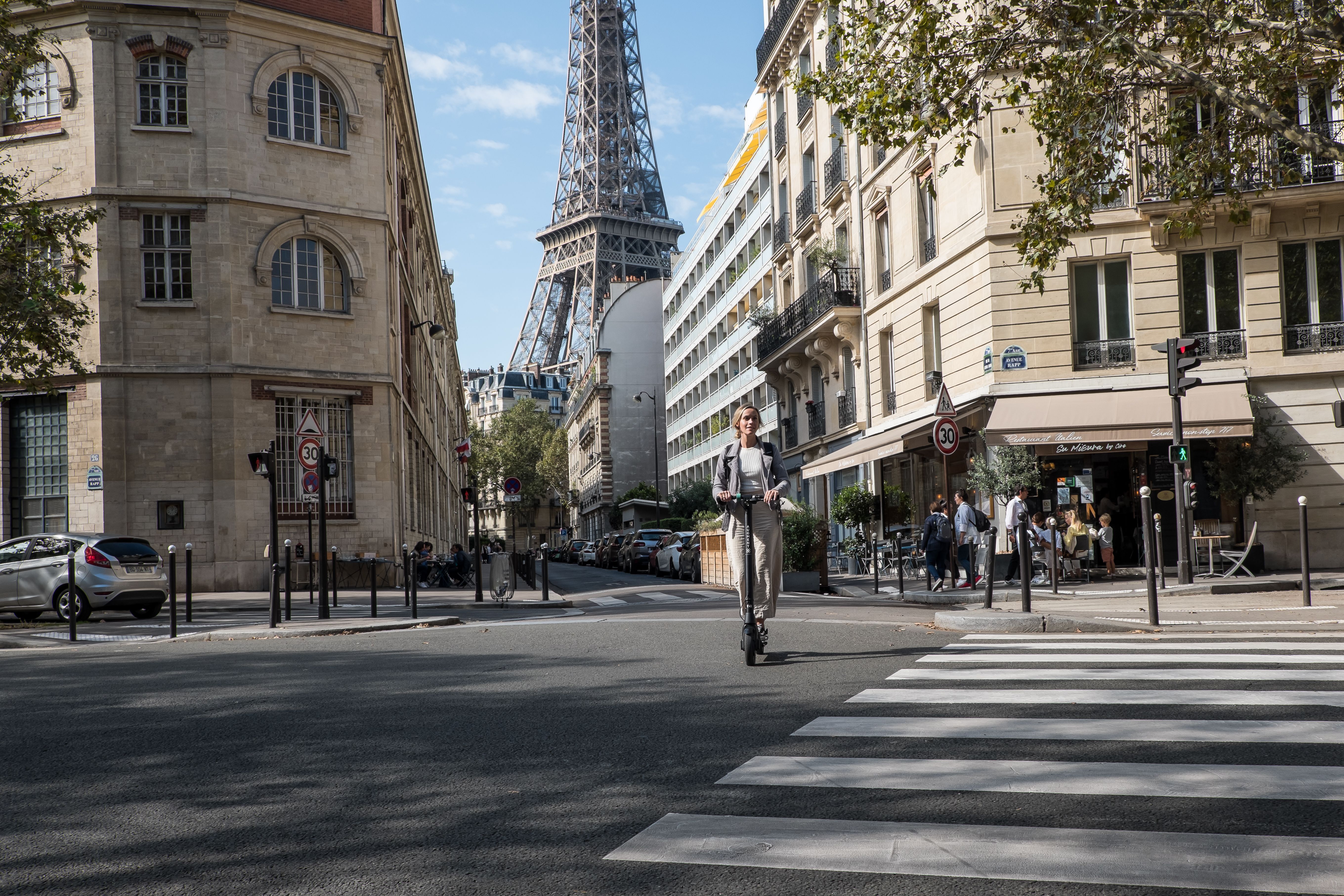 Une femme conduit un scooter électrique Augment dans une ville.