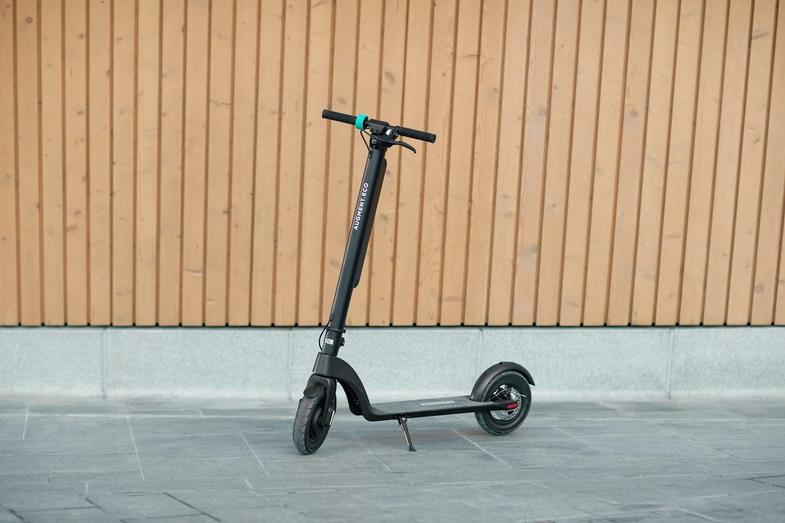 Augment e-scooter side view in front of wooden wall