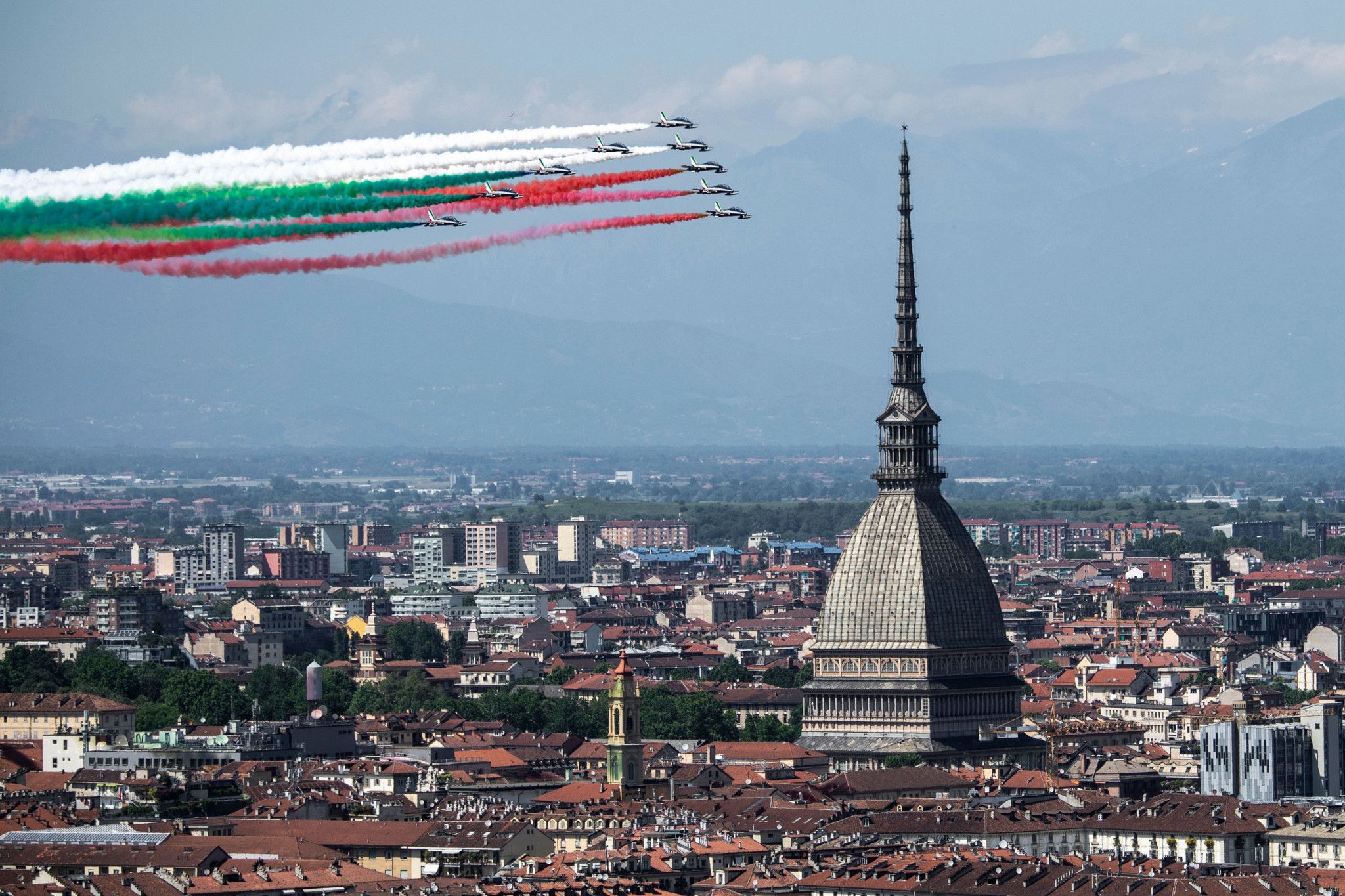 Panorama della città, su cui gli aerei del cielo creano la bandiera italiana con fumi colorati