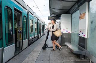 Woman entering train with an e-scooter