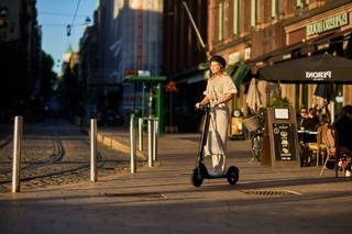 Nuori nainen ajaa Augment-sähköpotkulaudalla Helsingin keskustassa