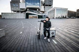 Person sitting with an e-scooter