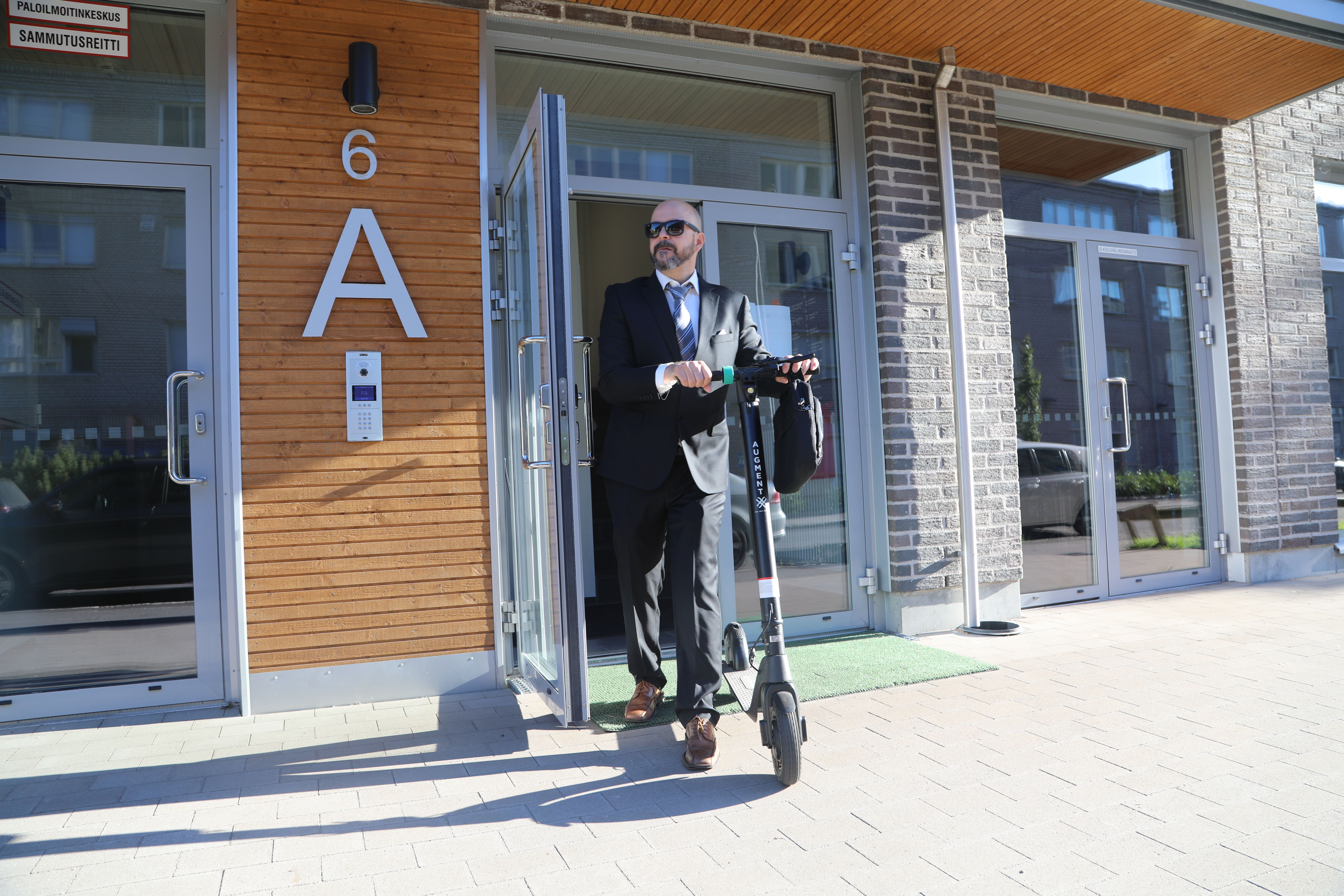 Advokat lämnar hemmet för att åka till jobbet på en sparkcykel