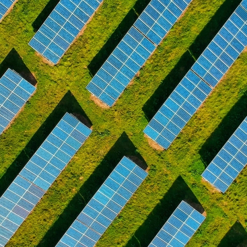 an aerial view of an array of solar panels on a grassy field