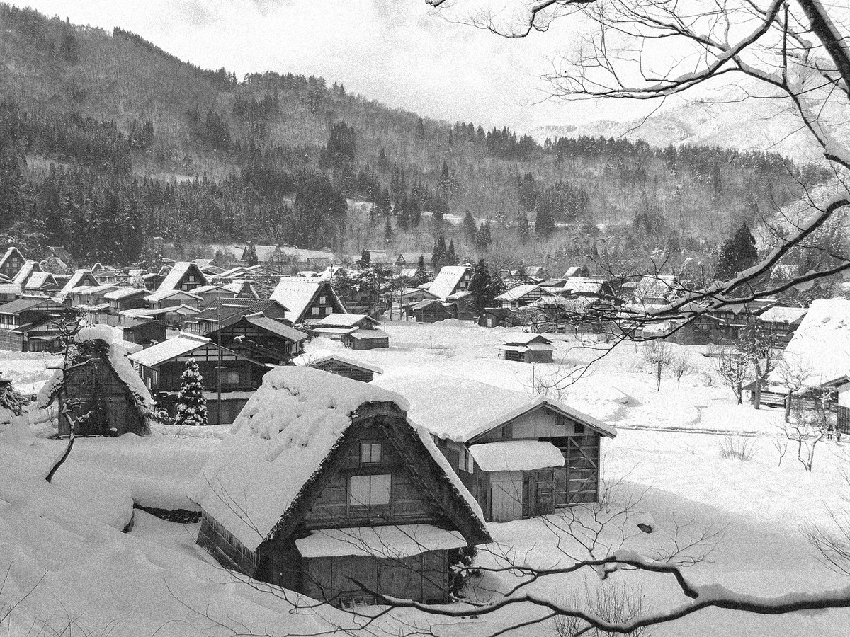 Ill. 4: Shirakawa-go om vinteren, dækket af sne. På billedet ses blandingen af de gamle gassho-zukuri-huse og nye huse af en mere generisk slags, bygget efter byen brød ud af sin isolation.