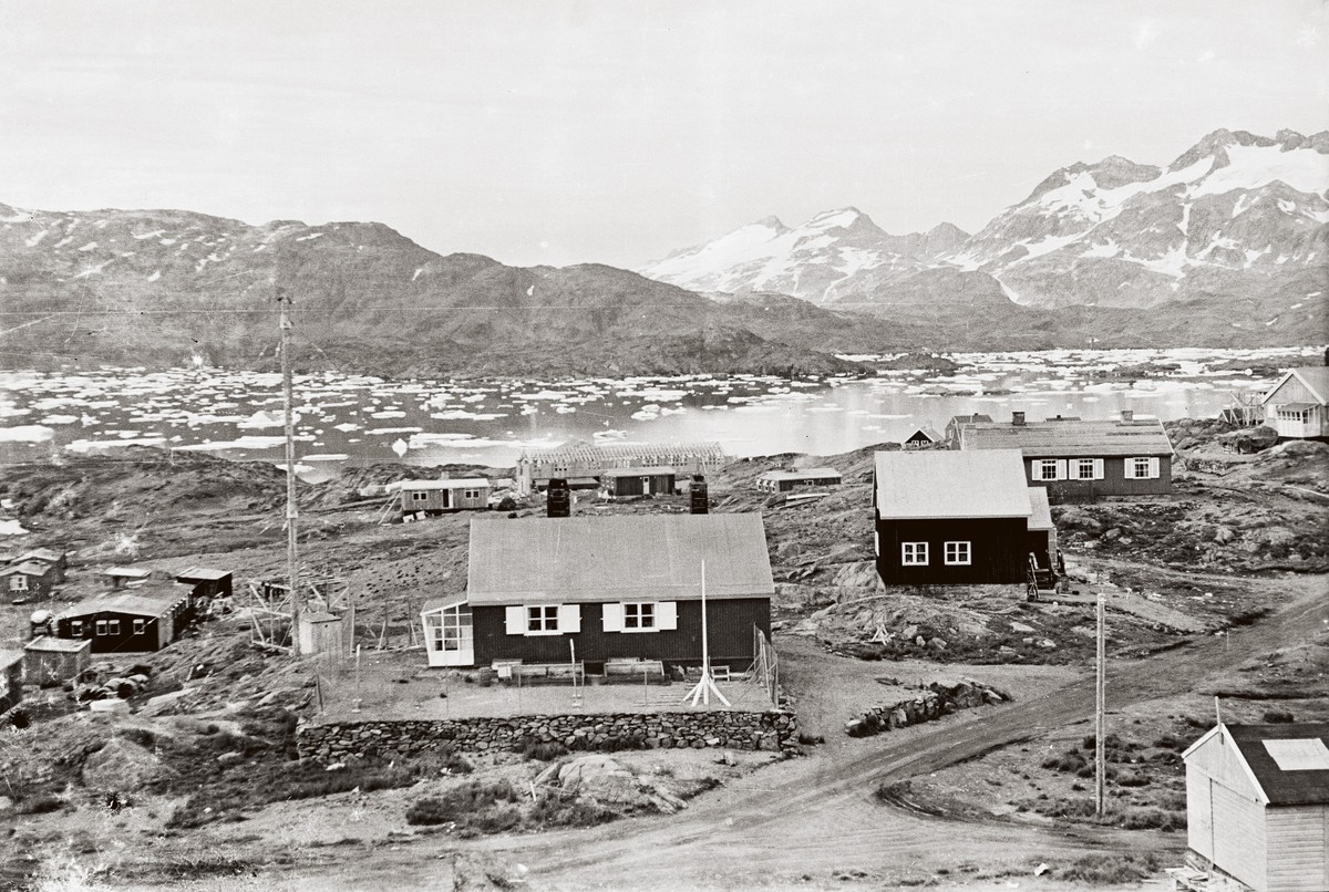 Ill. 13. Danskernes huse, sommeren 1956: Fra venstre mod højre ses i forgrunden præsteboligen (1951), så skolelærerens lille hus (1951), telegrafstationen med bestyrerbolig (1948) og yderst i kanten til højre lægeboligen (1951). Bag præsteboligen anes spærene på de nye sygehus, der er under opførelse.