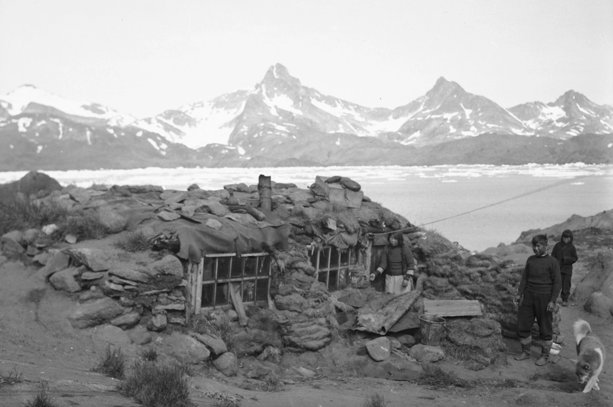 Ill. 4. Et vinterhus i Ammassalik 1935 ses her med indrammede glasvinduer, mens en skorsten titter op i taget fra en jernovn. Foto: Helge Larsen, tilhører Arktisk Institut.
