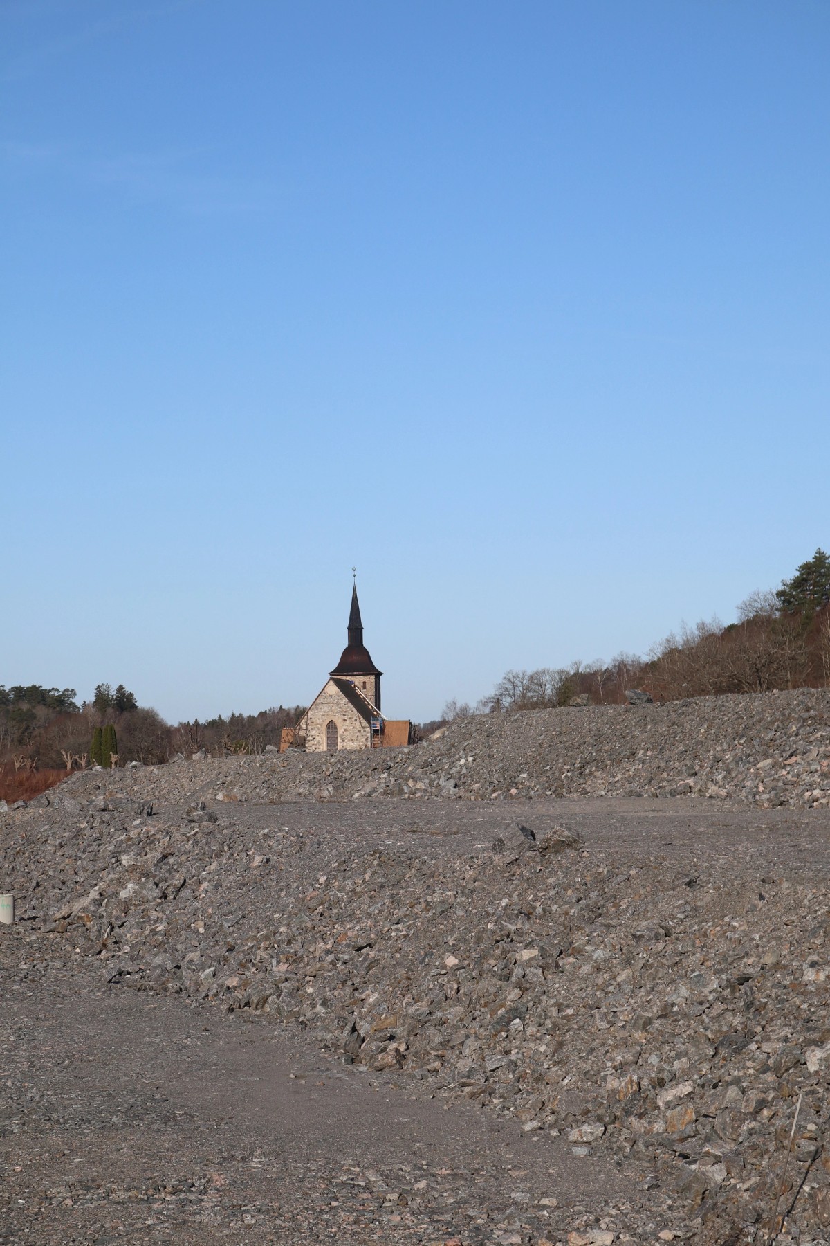 Ill. 5. Moderna bygg produktionsmetoder innebär ofta plansprängning av berg eller barskrapning av mark på bekostnad av lokalbiodiversitet. Förvaring av bergskross vid en medeltida miljö med kyrka från 1100-talet. Lone-Pia Bach