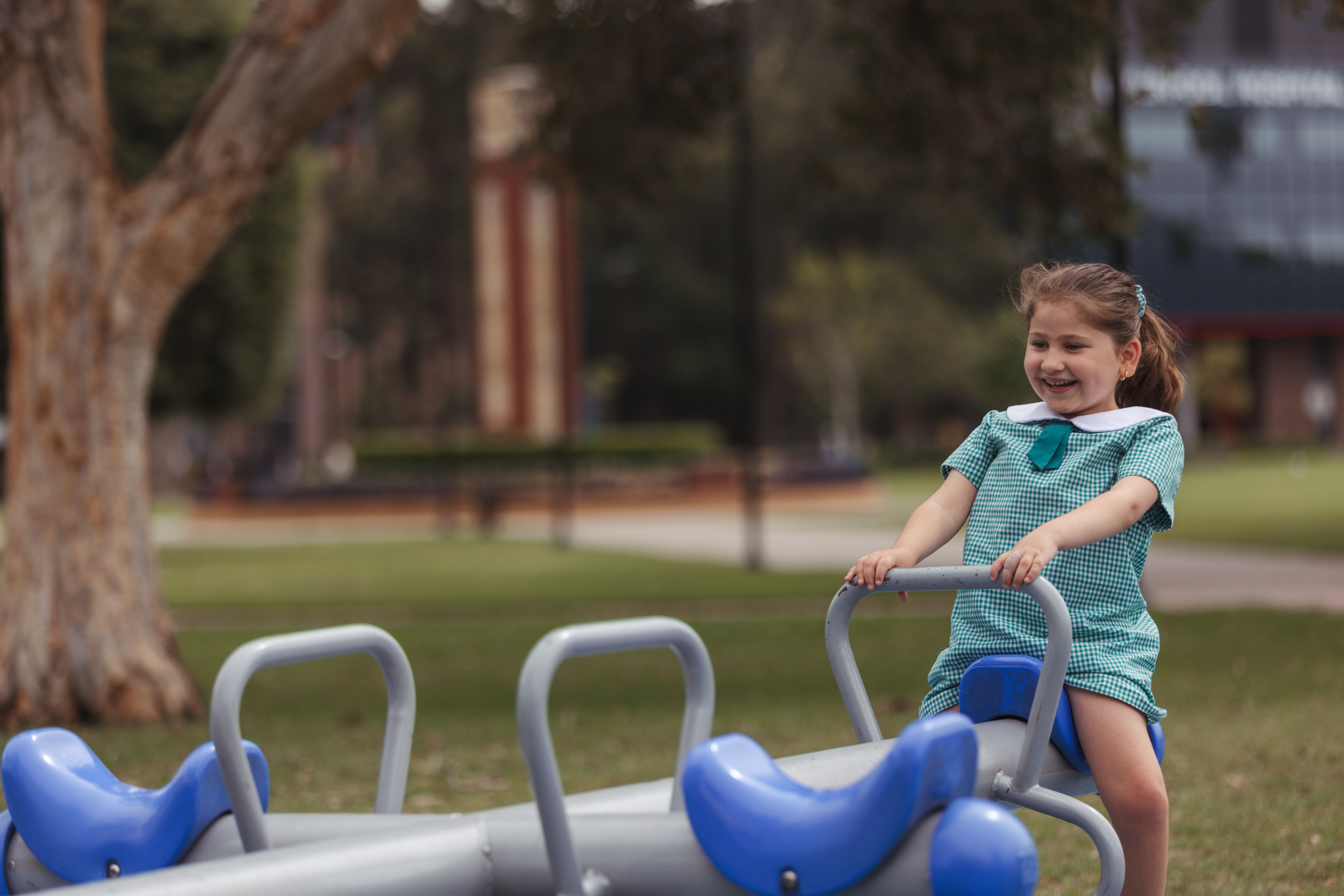 Child in a school uniform playing on playground equipment