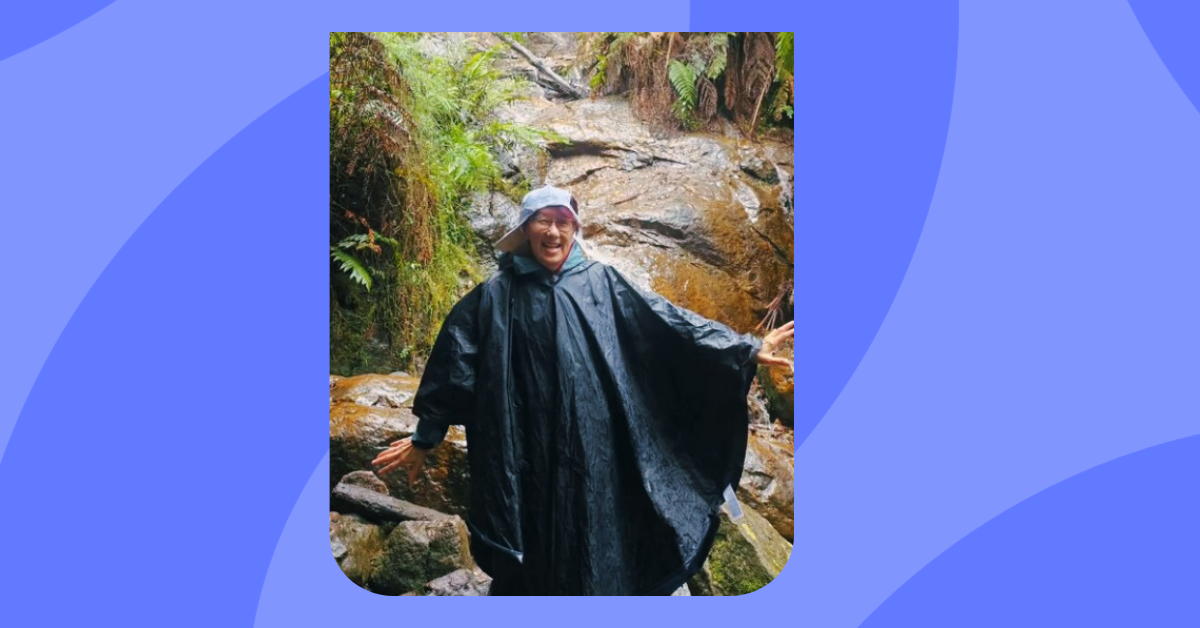 Carer in a jacket, standing in front of a waterfall