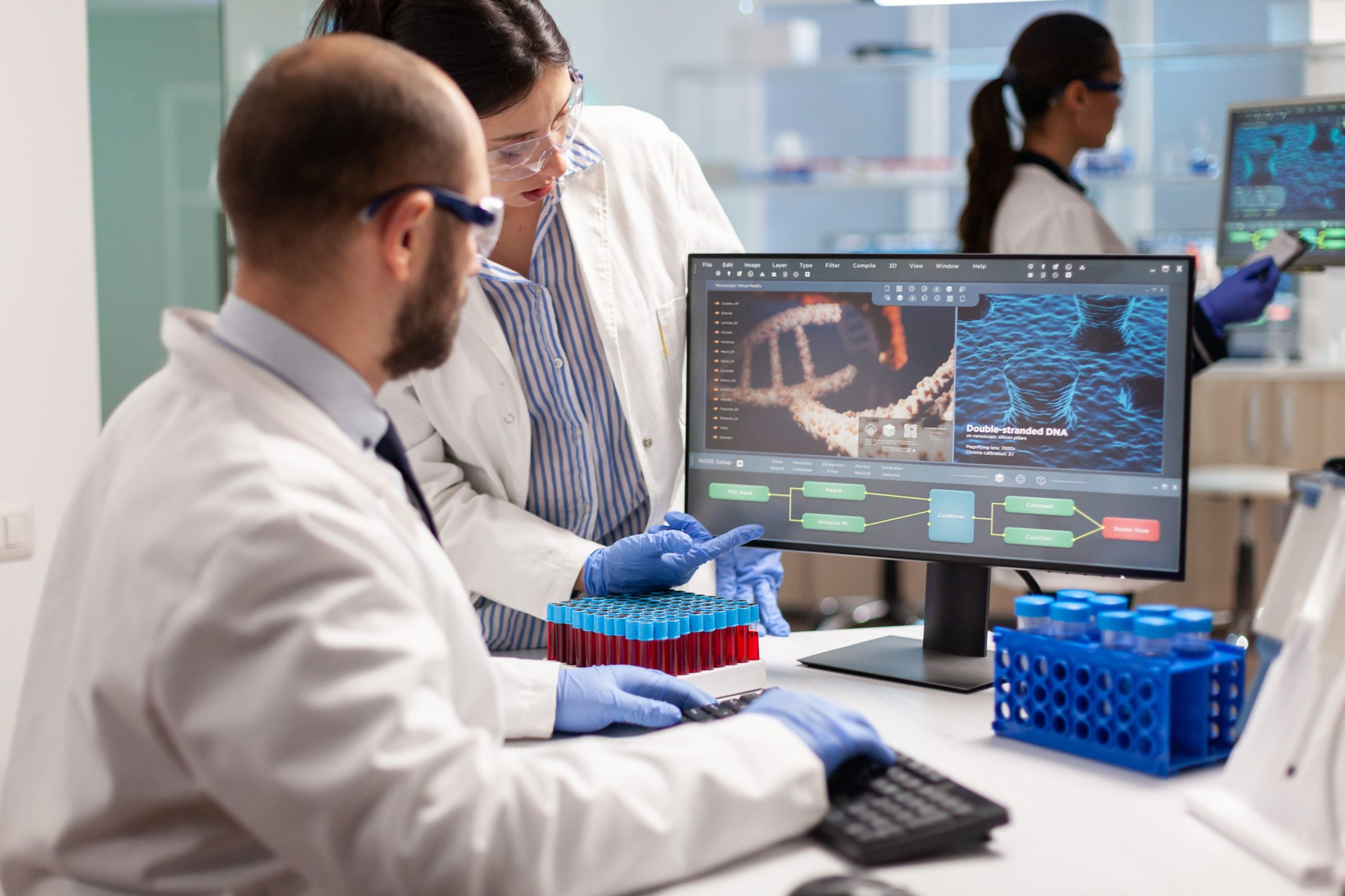 Two deakin researchers in lab coats looking at a computer