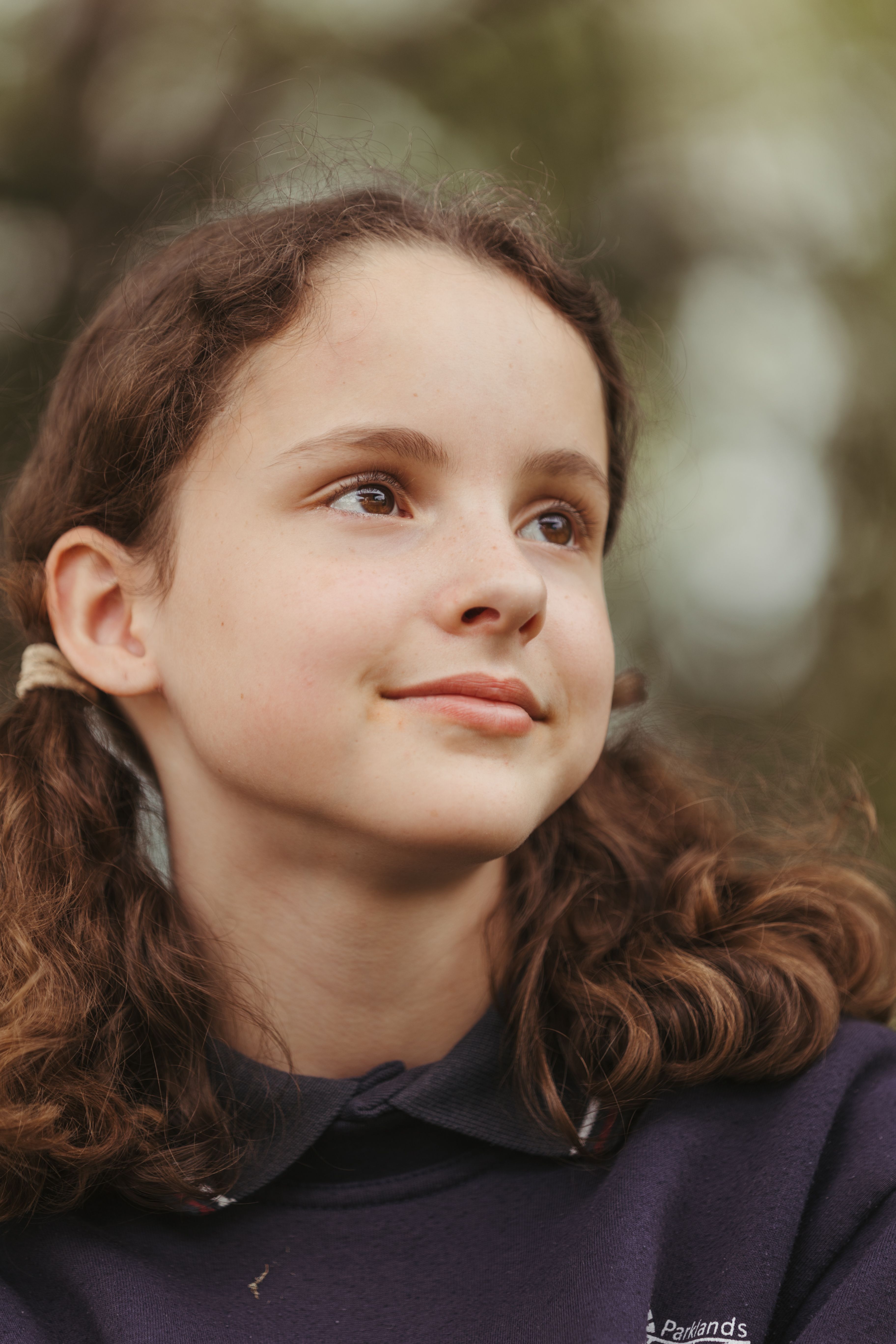 Close up of the face of a school girl, about 9 years old, looking away into the distance