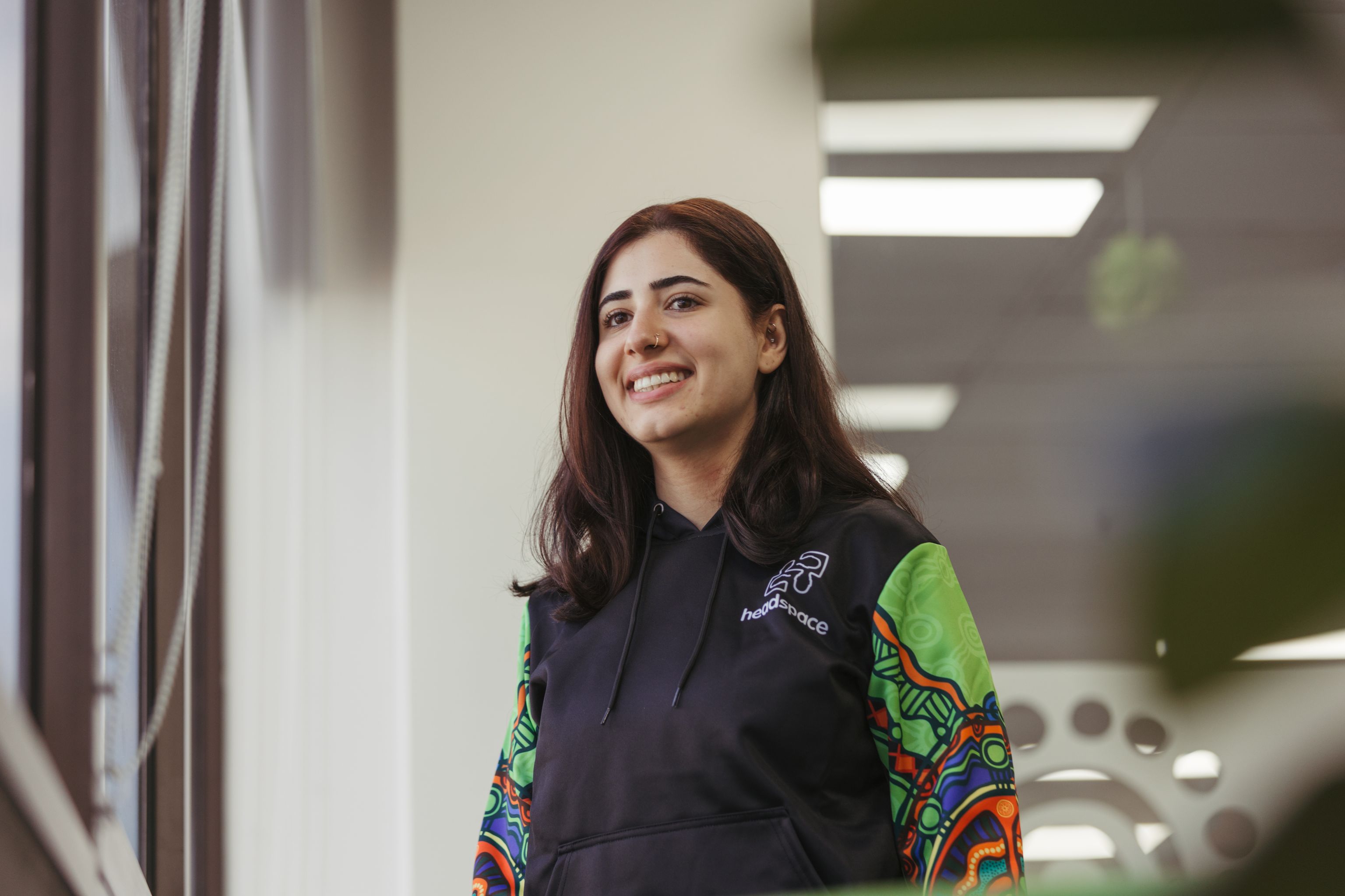 Staff member from headspace standing in office and looking out of a window