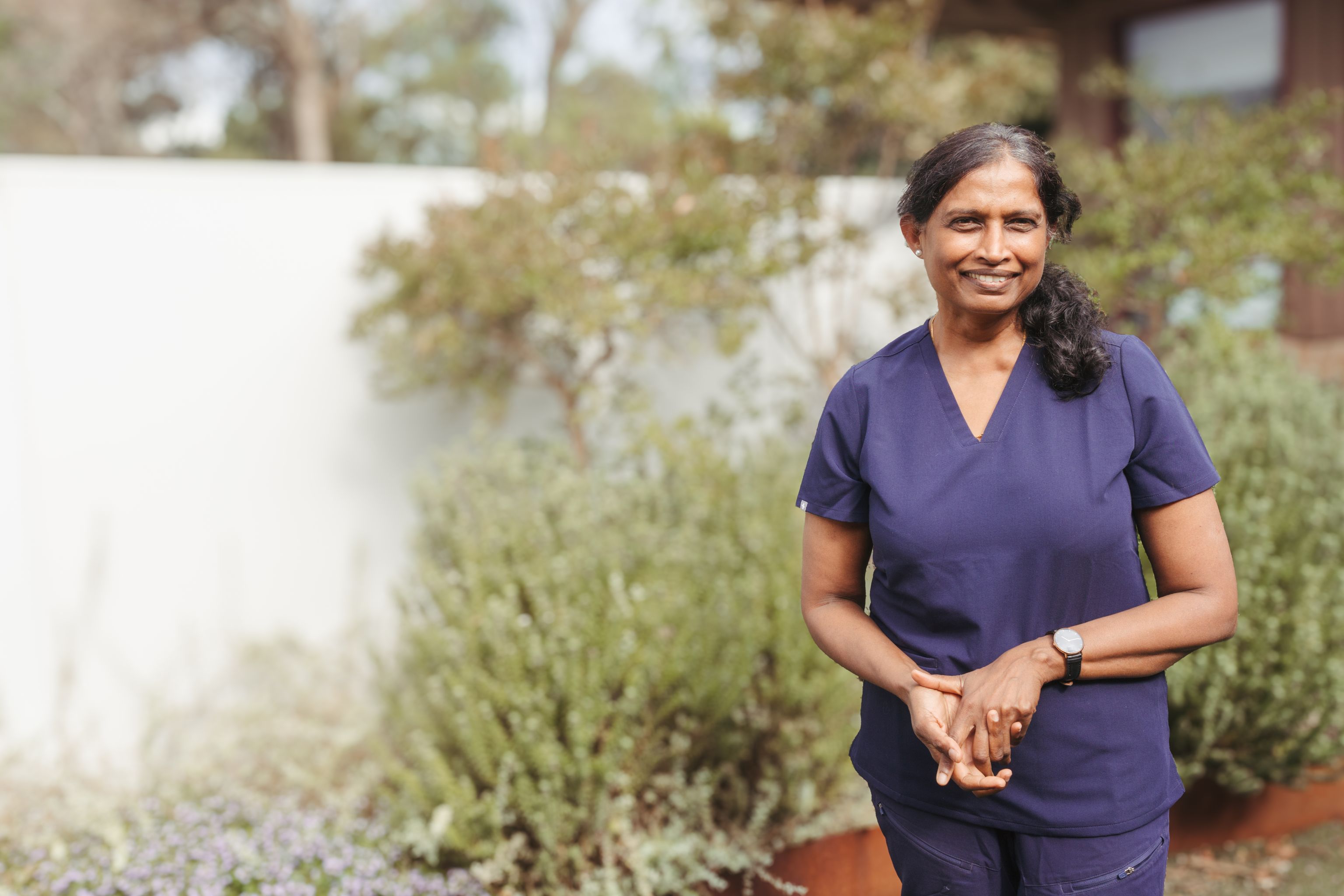 Each clinician wearing scrubs standing outside and smiling