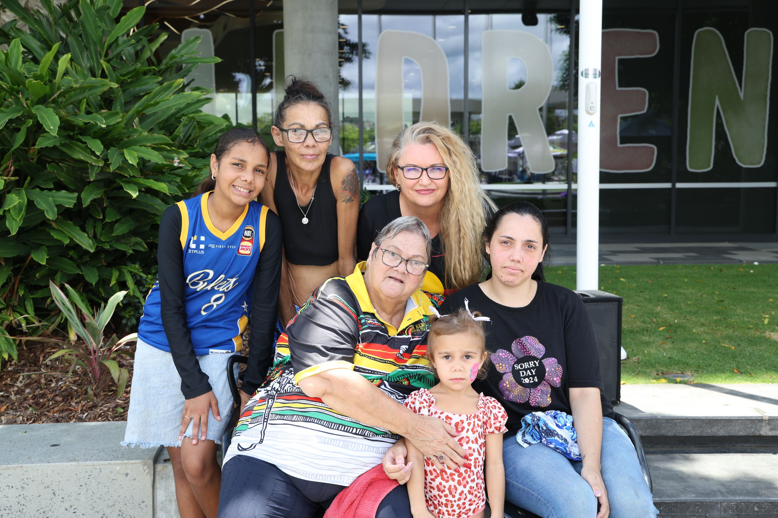 A group of first nations people from different generations sitting outside a centre
