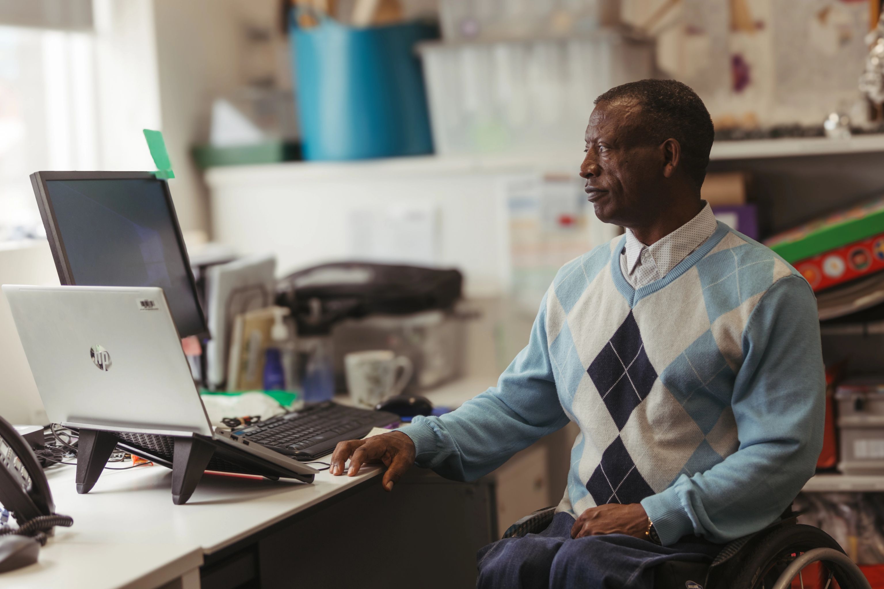 Each worker in a wheelchair sitting at his desk