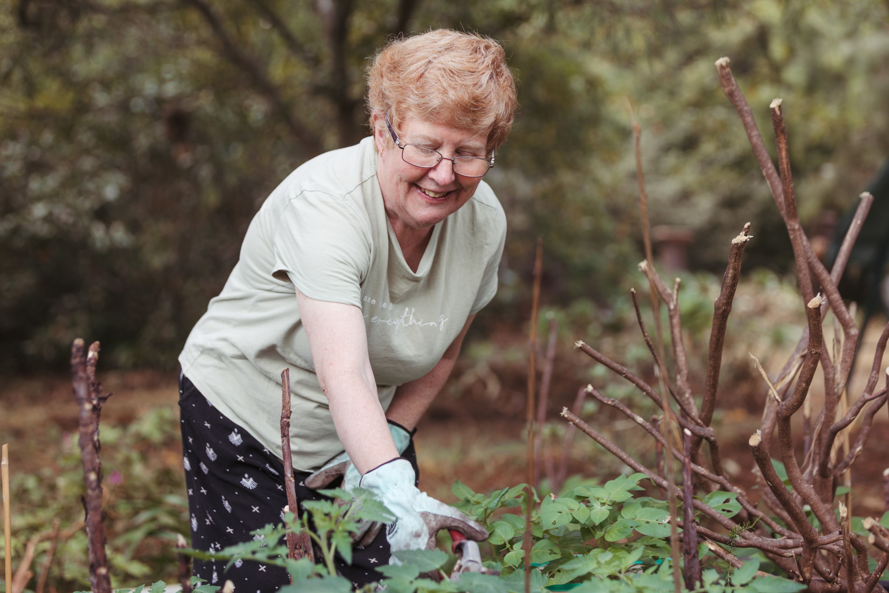 Christine is in her garden watering some plants.