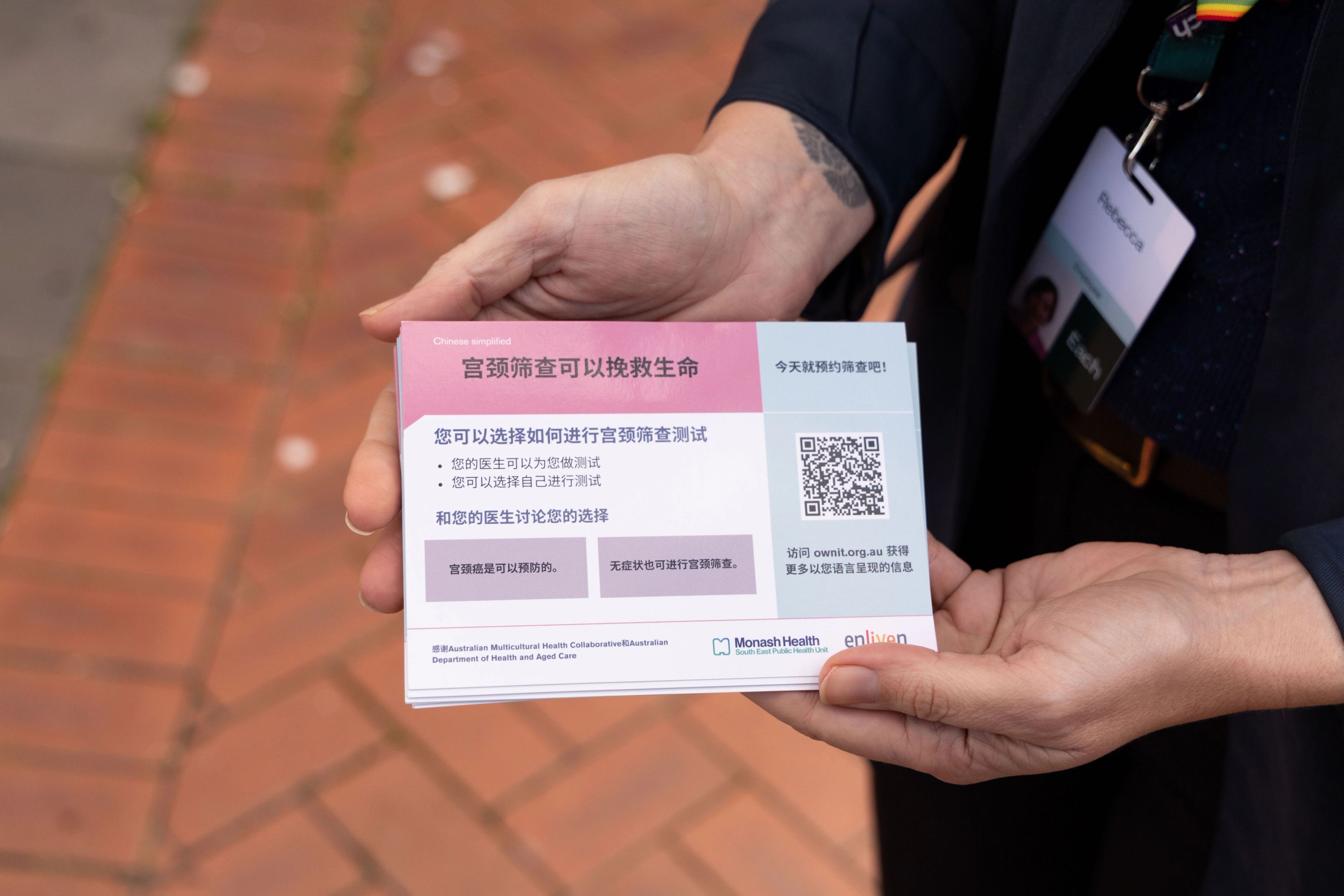 Hands holding a card with information on it in Chinese about cervical screening.