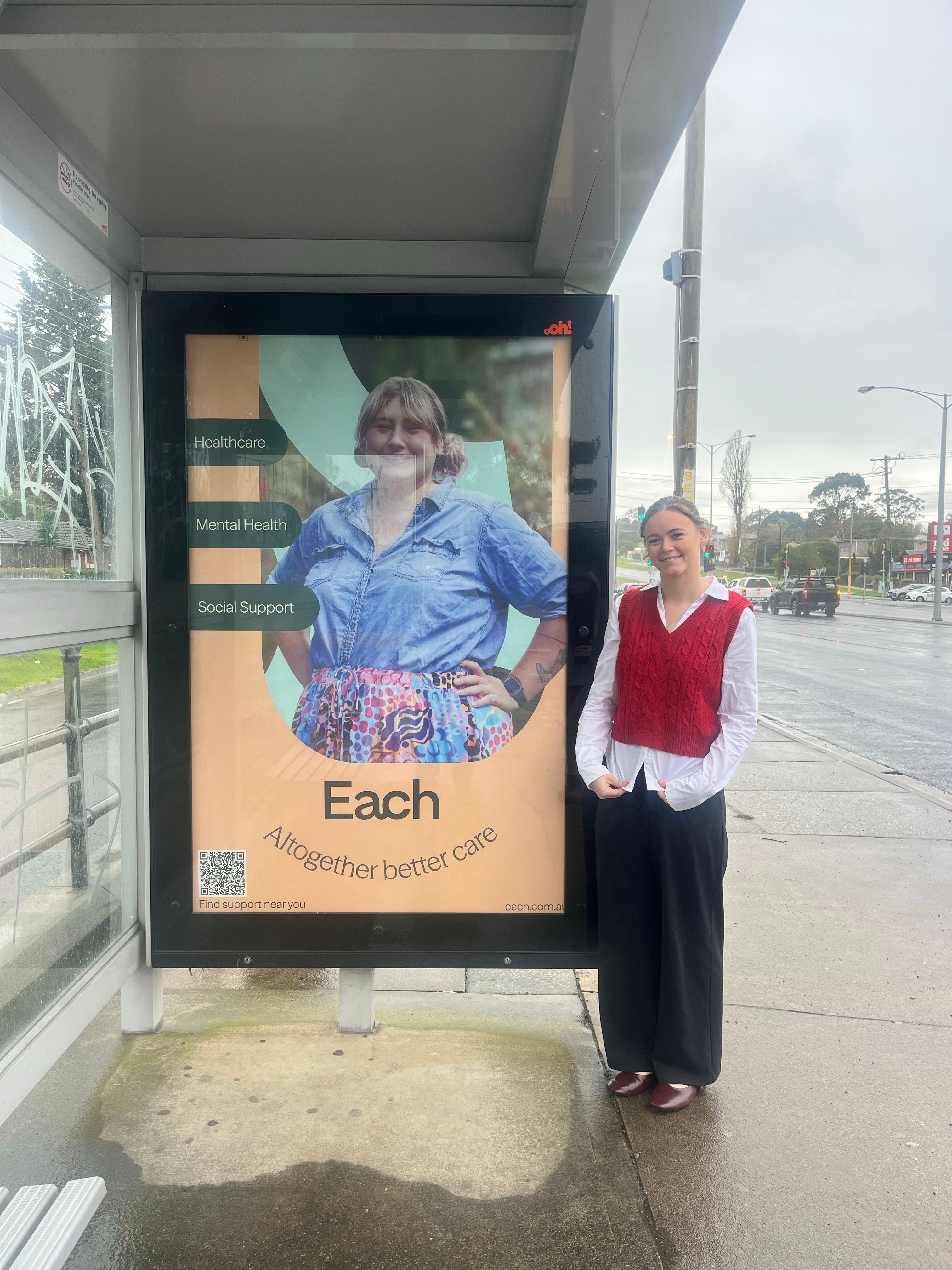 Ebony standing next to her bus-shelter artwork.