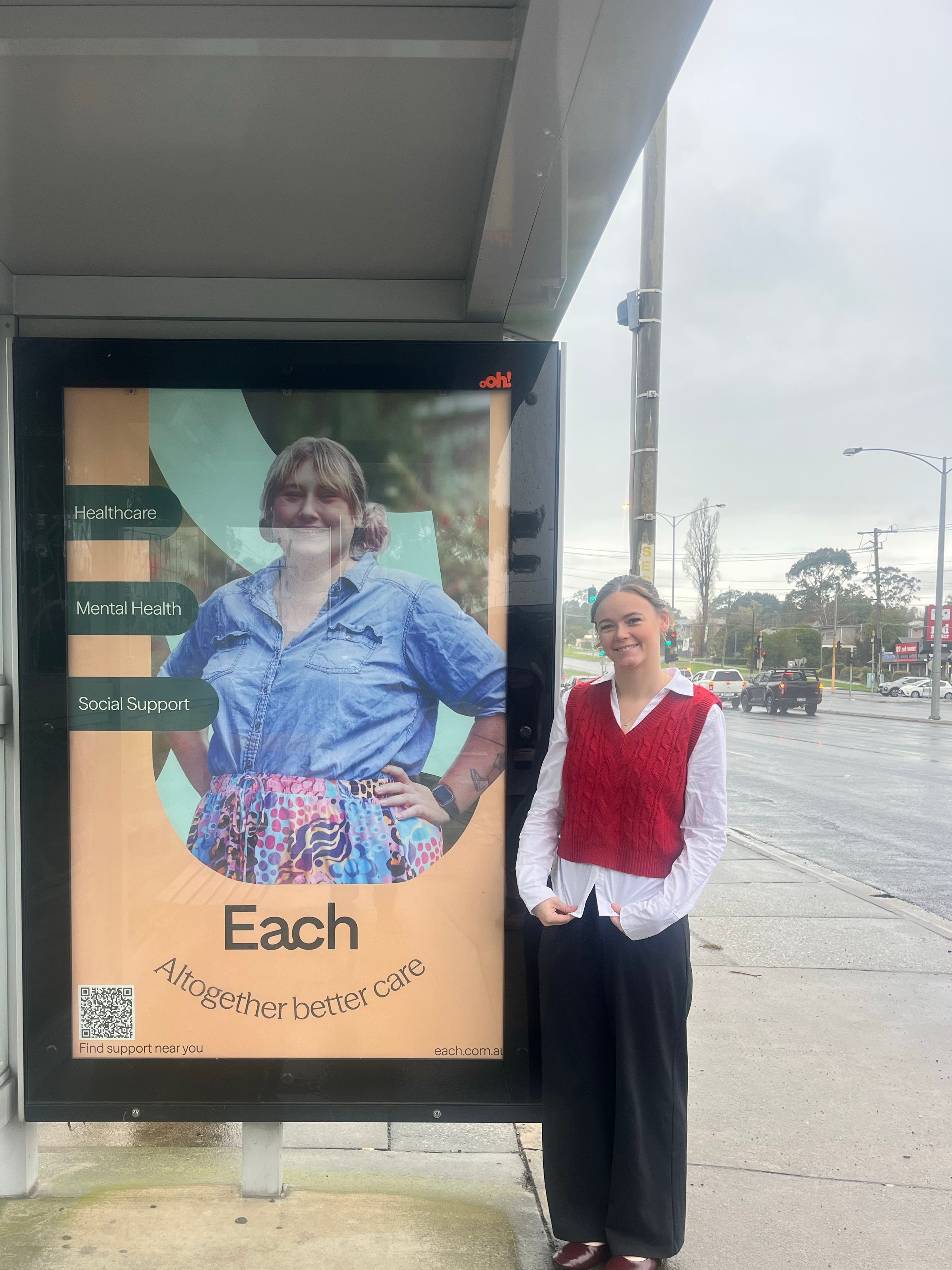 Ebony standing next to her bus-shelter artwork.