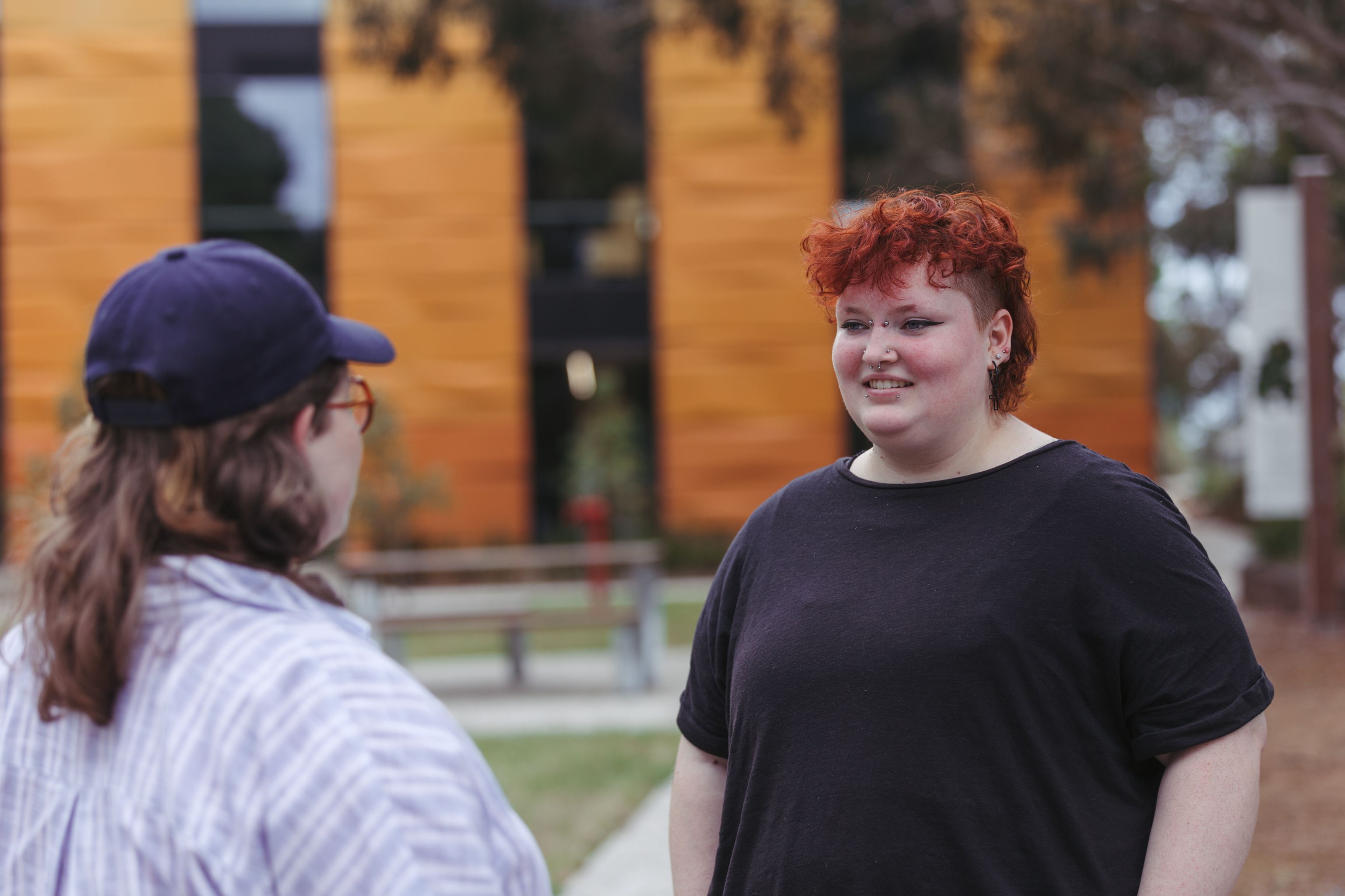 Close up of two LGBTQIA+ people chatting outside