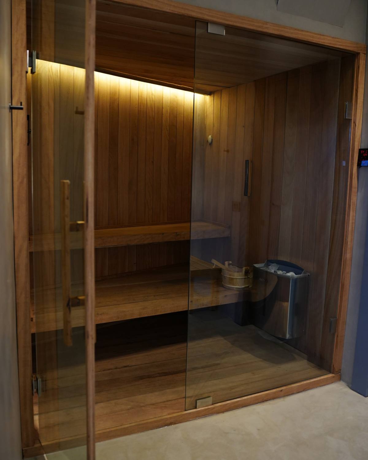 The custom wood sauna behind glass doors
