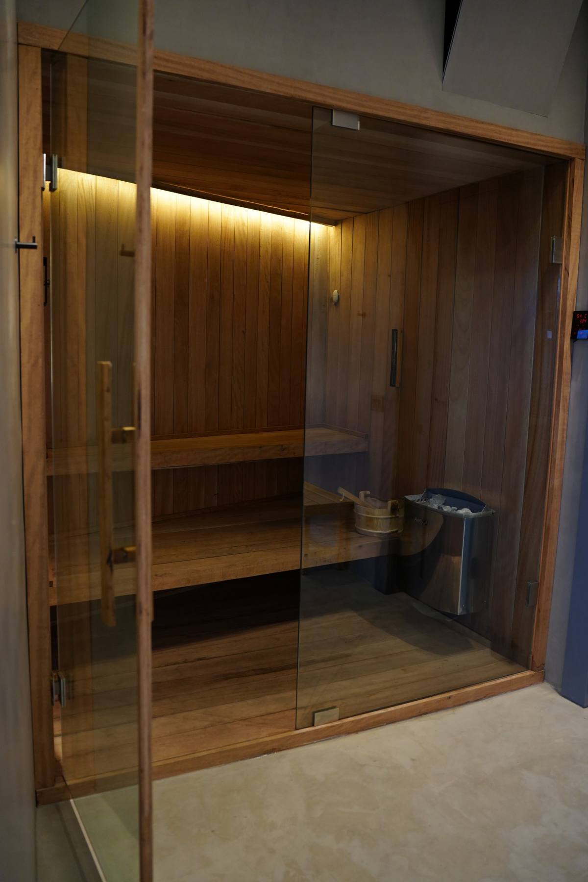 The custom wood sauna behind glass doors