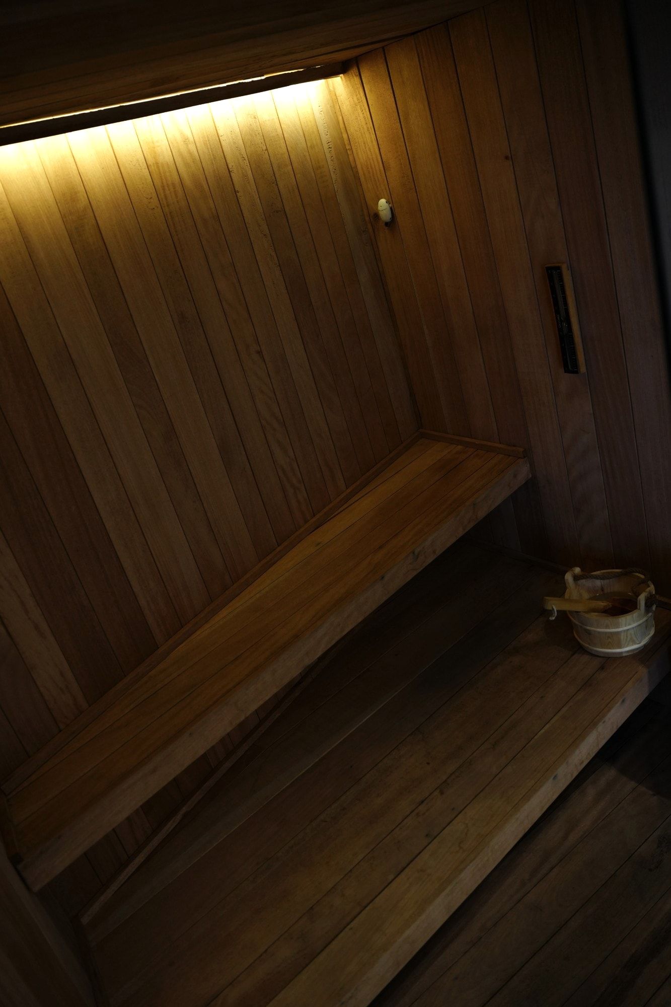 Inside the sauna: warm-lit wood benches