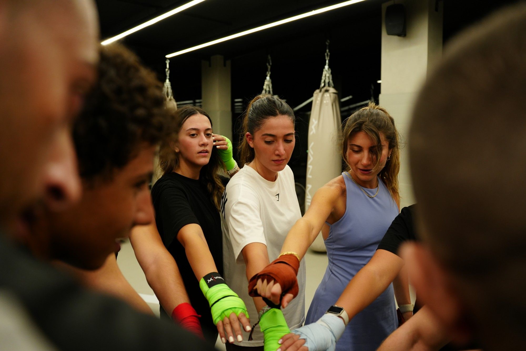 Women in hand wraps putting their hands in before class