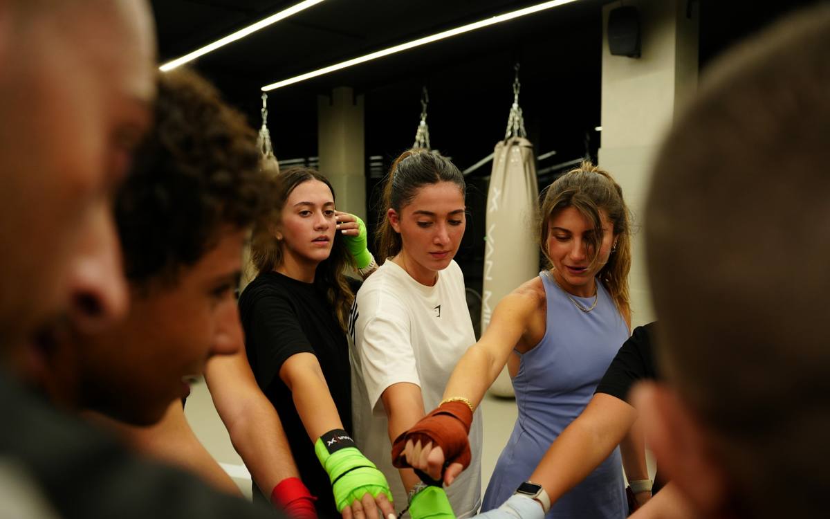 Women in hand wraps putting their hands in before class