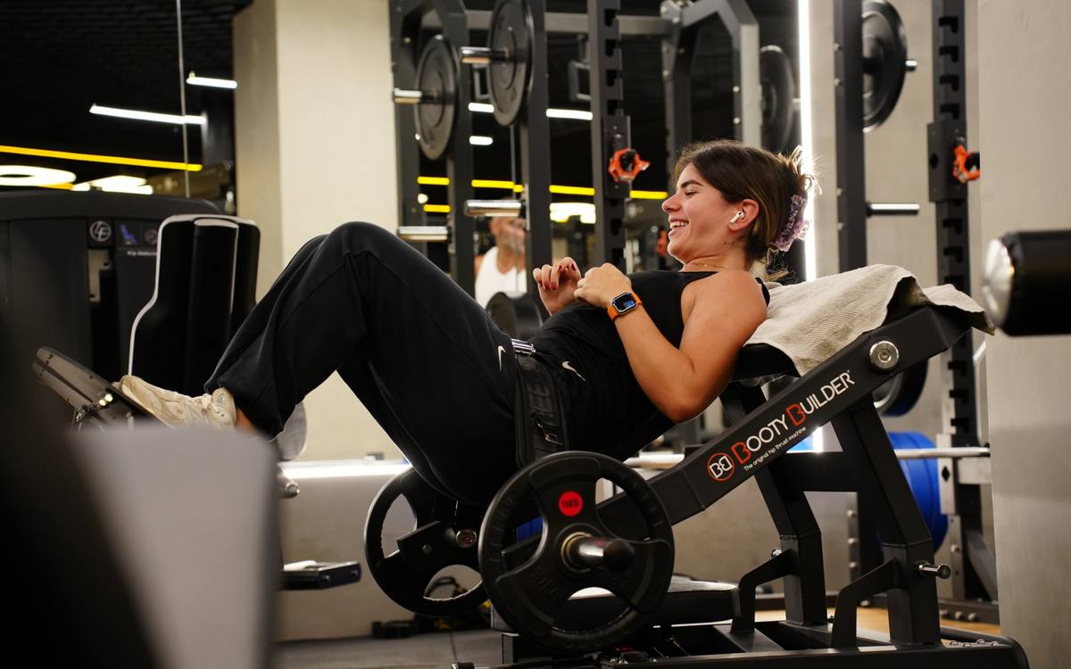 Member laughing mid-set on the Booty Builder hip thrust machine