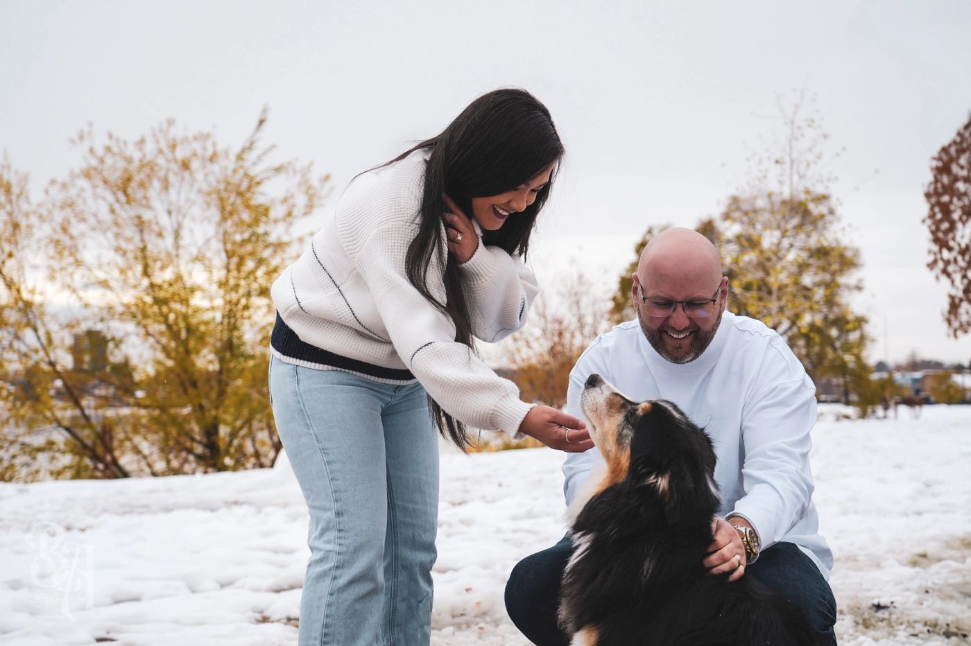 Jaury and Tyler playing with their dog Ollie in the snow