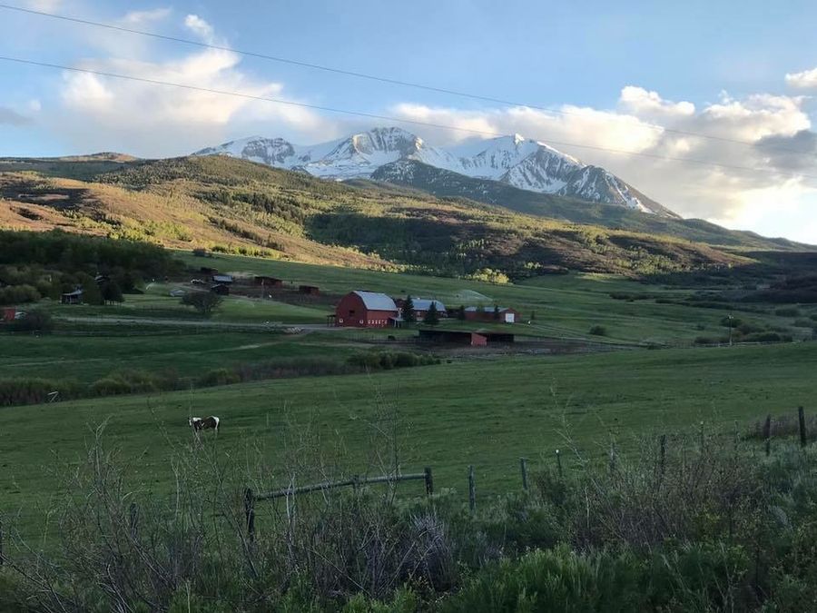 Rustic barn surrounded by mountain scenery in Snowmass, Colorado.