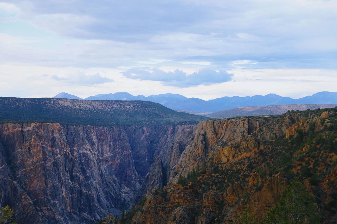 Black Canyon of the Gunnison surrounded by rugged Colorado landscape in summer.