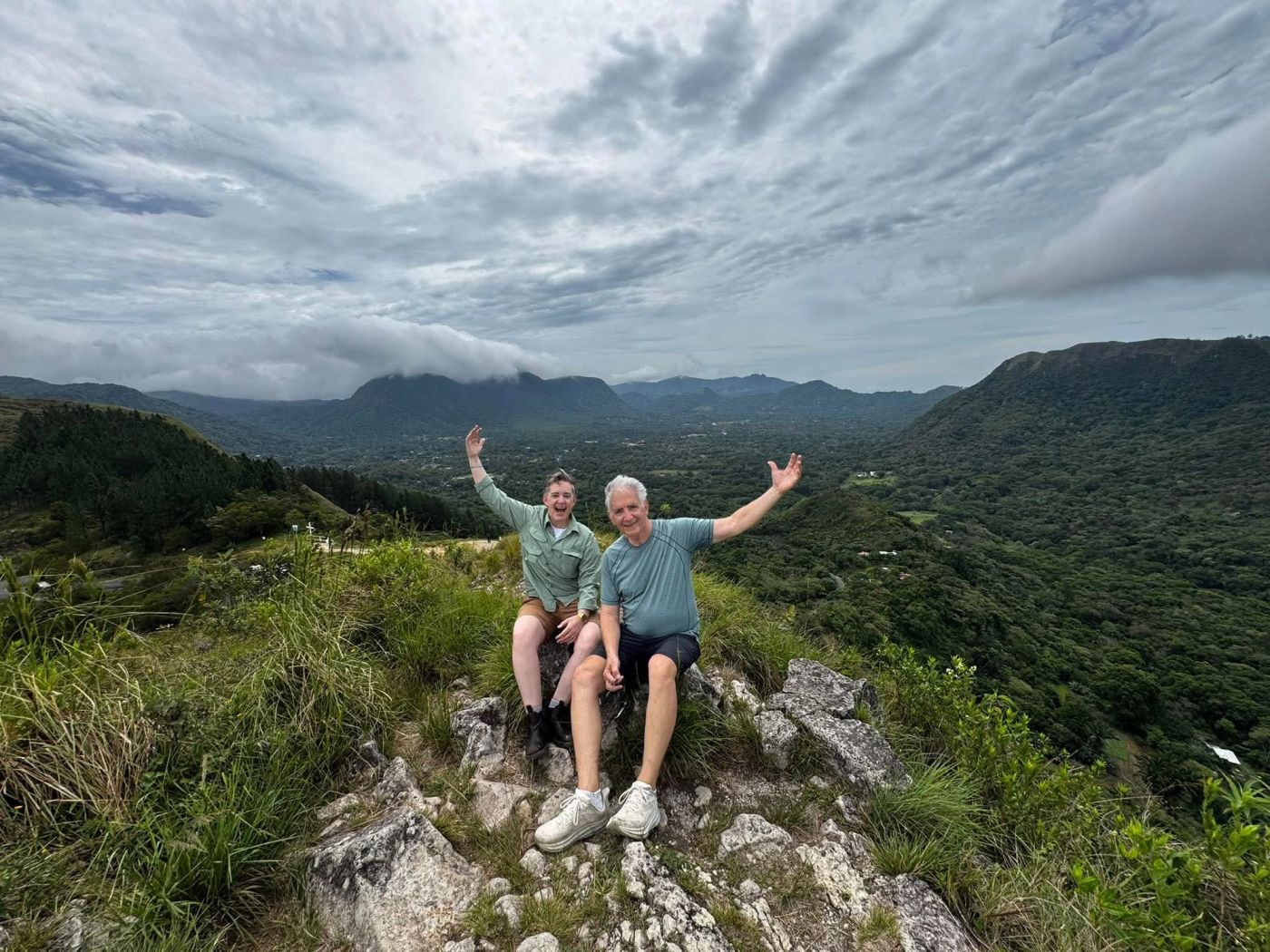 Two travelers celebrating on a mountain overlook above El Valle de Anton