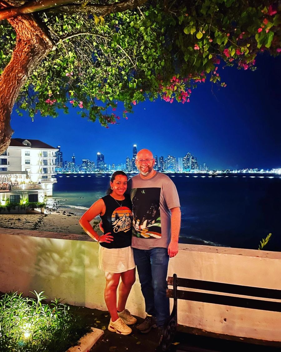 Jaury and Tyler Wofford in Casco Viejo at night with the Panama City skyline across the bay