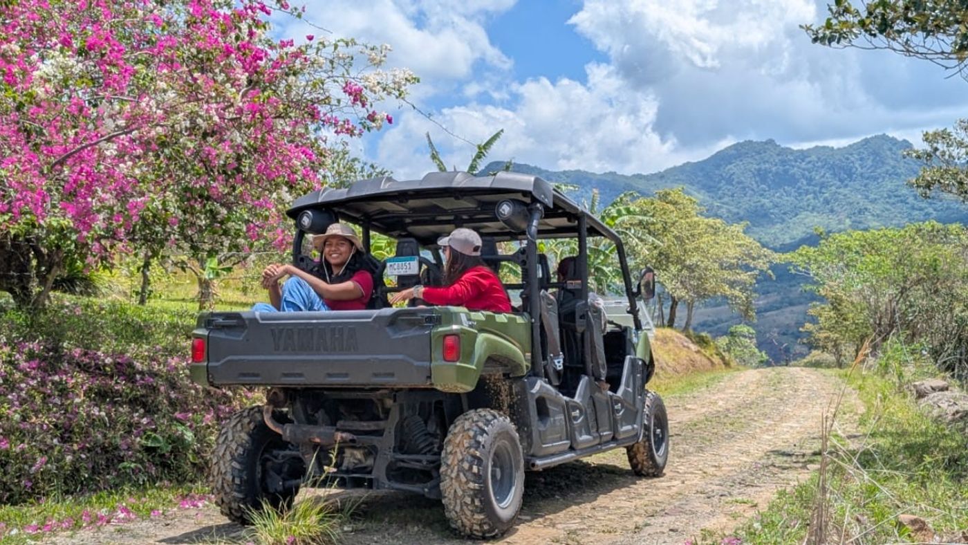 Travelers riding a UTV along a dirt road through the Panama highlands
