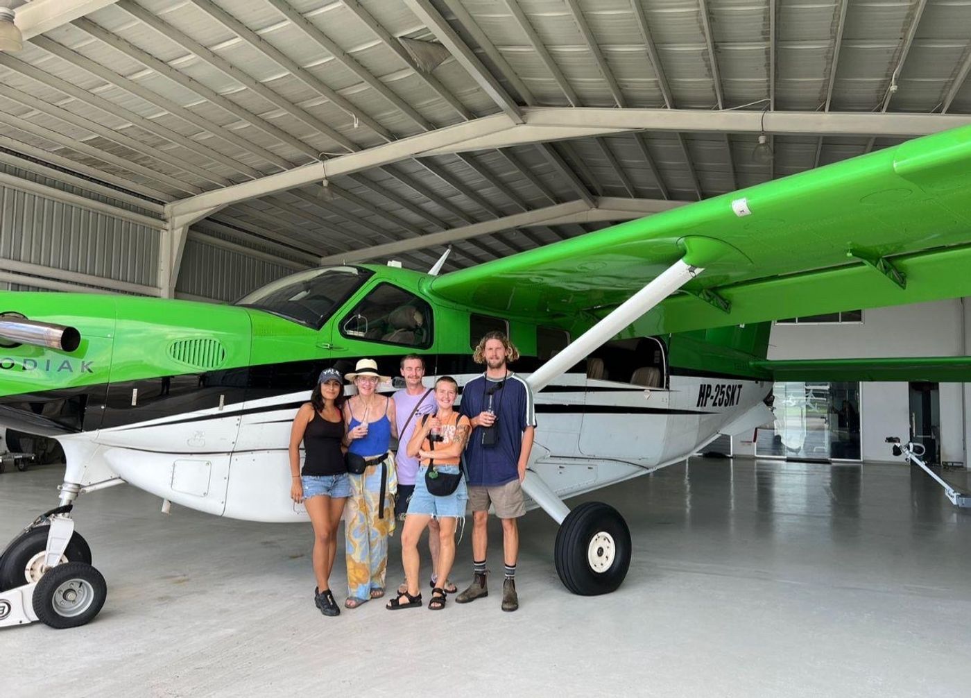 Four travelers standing beside a private plane in Panama as part of a customized private vacation.