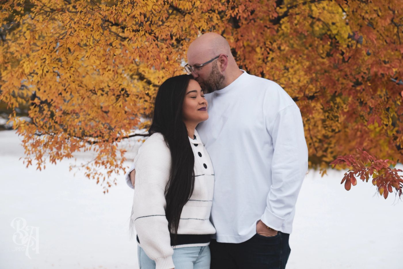 Tyler kissing Jaury on the forehead under golden fall leaves in Colorado