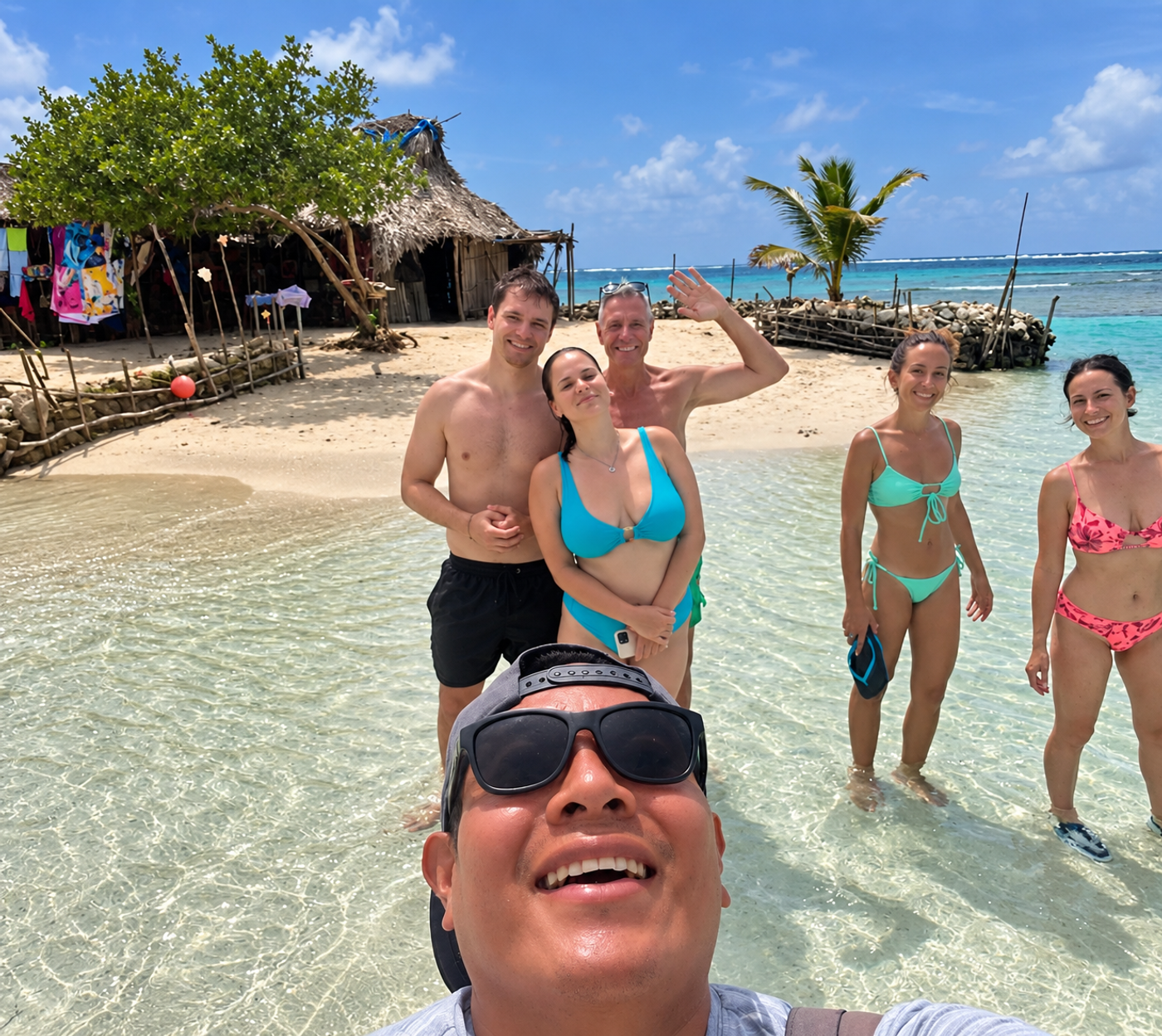 Victor with a group of visitors in clear shallow water on a Guna Yala island
