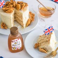 a bottle of roose honey next to a slice of cake