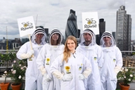 a group of people in beekeeper suits holding signs that say Rowse