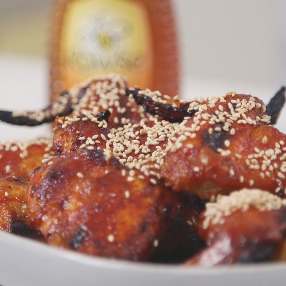 a close up of a plate of chicken wings with sesame seeds on a table .