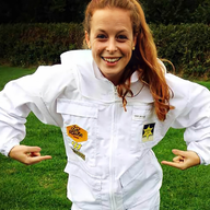 a woman wearing a bee suit has a patch on her chest that says bee hive