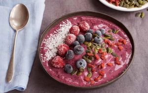 Antioxidant purple smoothie bowl with frozen berries and coconut