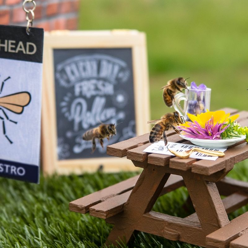 a group of bees are sitting at a wooden picnic table .