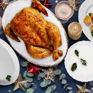 there is a roasted chicken on a plate on the table .