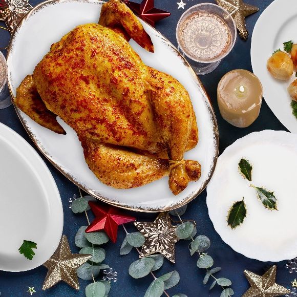 there is a roasted chicken on a plate on the table .