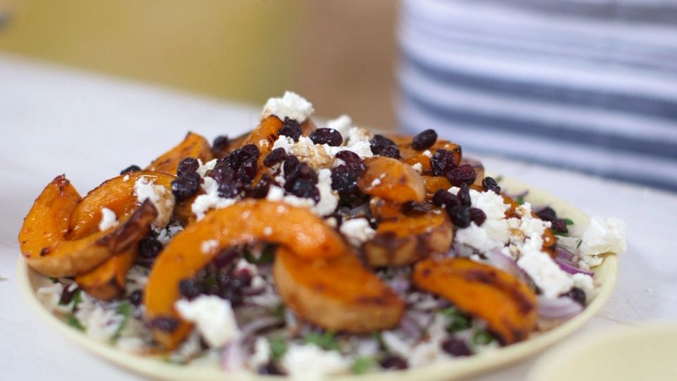 a close up of a plate of honey roast squash salad on a table .