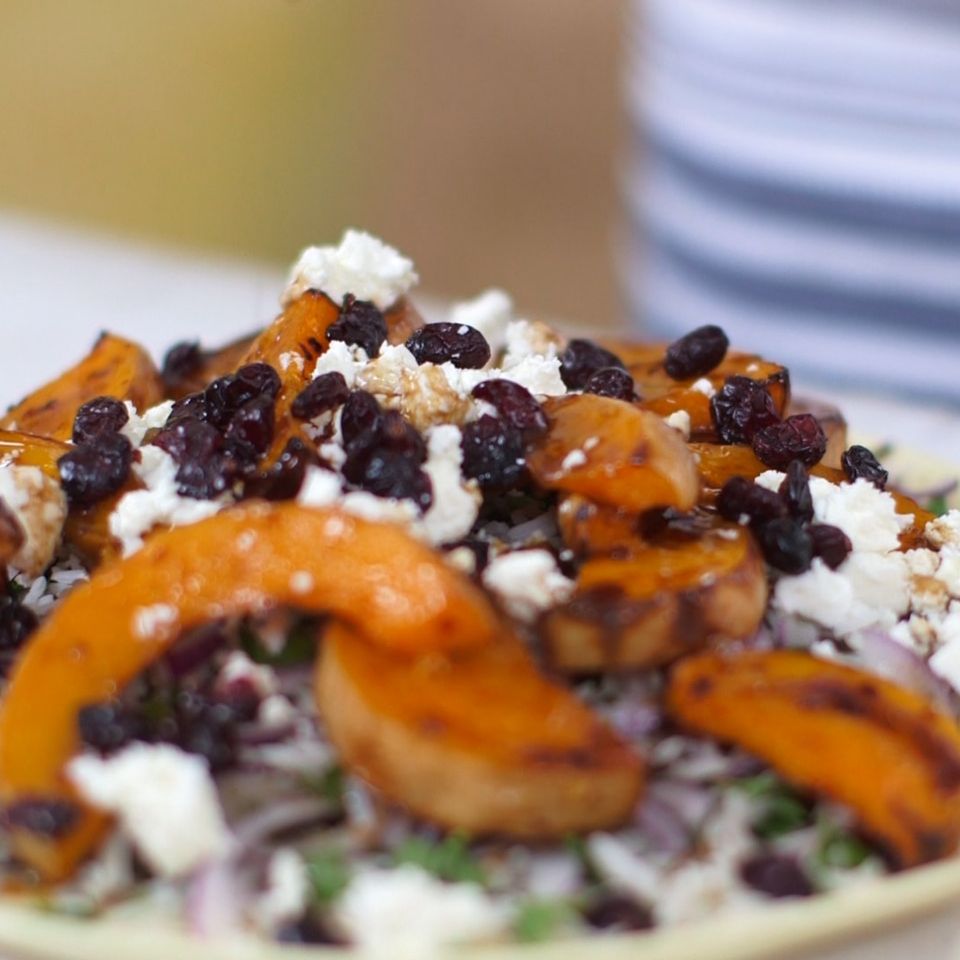 a close up of a plate of honey roast squash salad on a table .